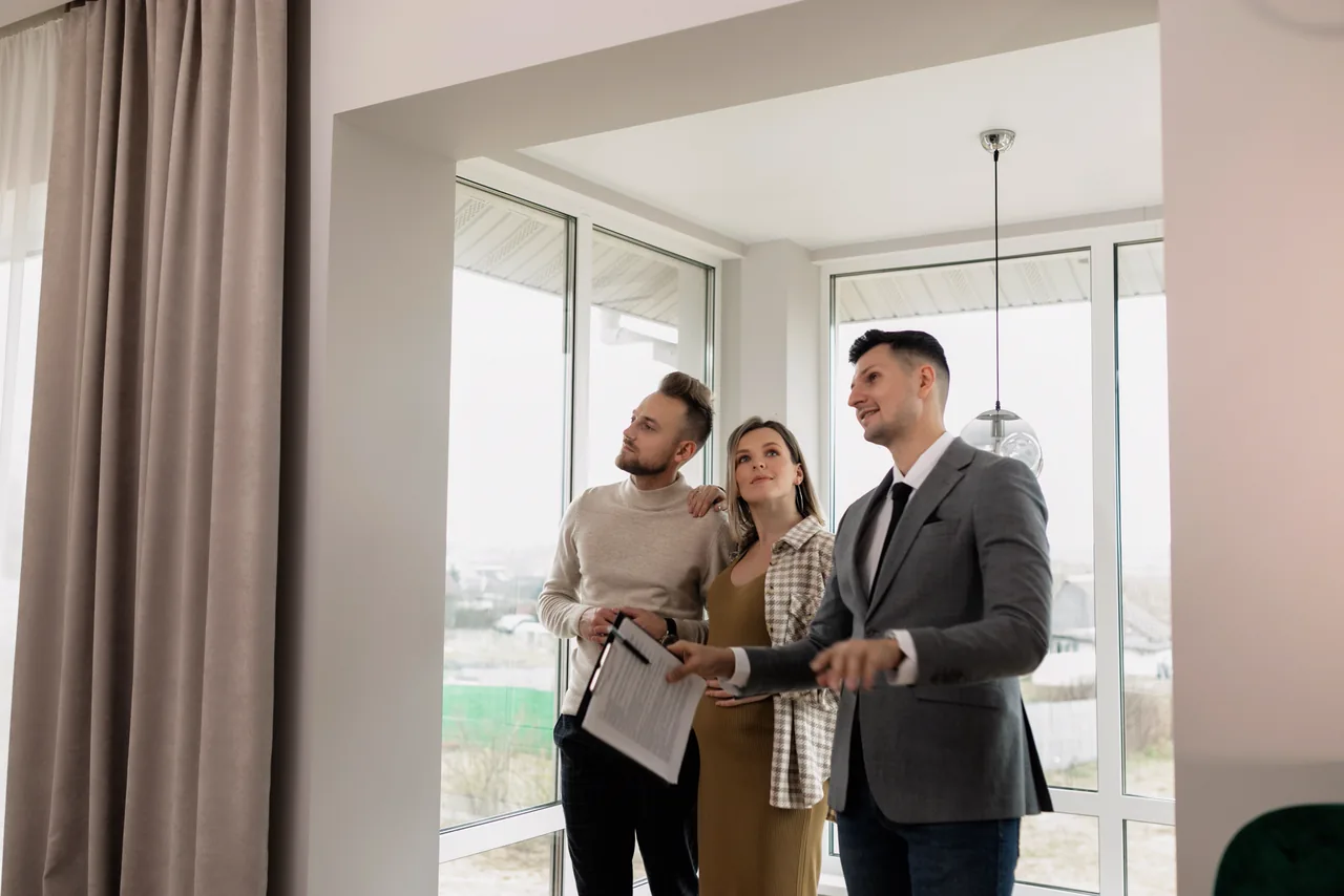 A real estate agent showing a home to a young couple